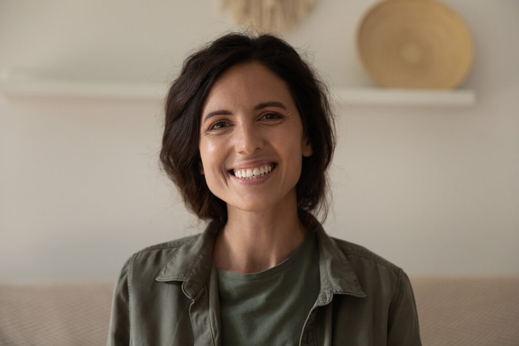 A woman with shoulder length hair is smiling at the camera.