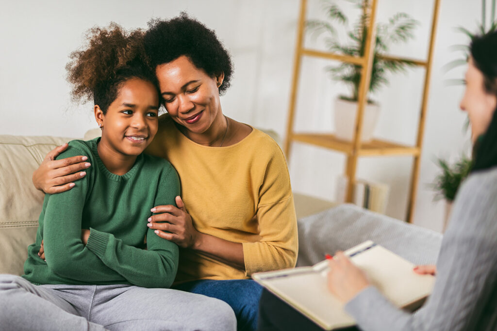 A mother and daughter are embracing while in family counseling