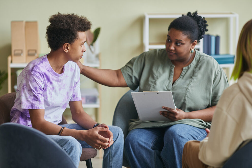 A therapist is leading a coup of teens in group therapy.