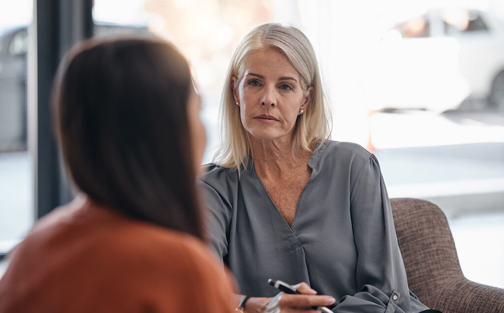 A therapist is listening closely as her client shares something with her.